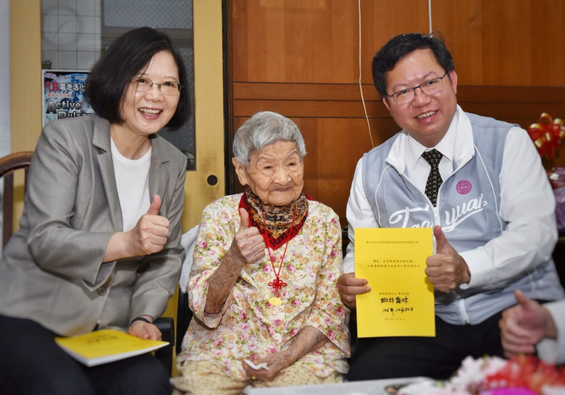 蔡英文總統和桃園市長鄭文燦手持百歲人瑞謝林霞妹的親筆簽名合影。   