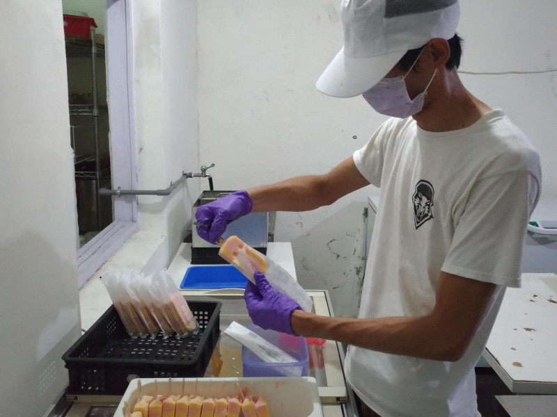 偉銘哥把冰棒一支一支的裝袋。 圖:小耕/攝