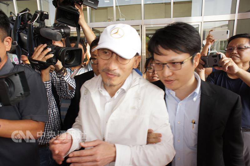 南投知名人士江欽良（中）涉嫌向南投縣草屯鎮農會詐貸，檢察官27日下午諭知江欽良以新台幣一千萬元交保，手續完成後，他由律師陪同快步離開地檢署，未多說話。   圖 : 中央社