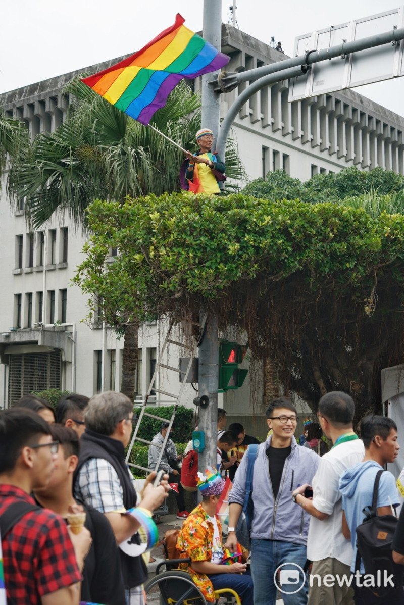 亞洲規模最大的2017同志大遊行剛得到今年總統文化獎的祁家威，站在高處，揮舞彩虹旗。   圖：張良一/攝