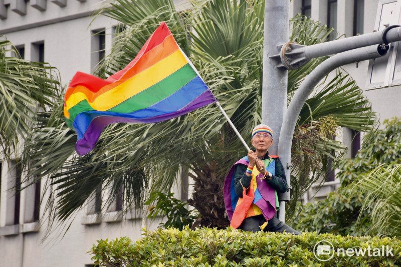 第15屆台灣同志遊行，投入婚姻平權運動多年的祁家威，總會選在遊行時，在高處搖彩虹旗，鼓舞參與的群眾。   圖：黃堃睿/提供
