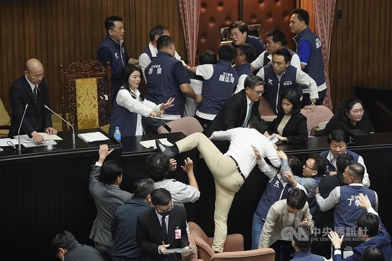 立法院於民國113年5月17日審議國會職權相關法案，在處理報告事項逕付二讀、進行表決時，民進黨立委郭國文（卡其褲）試圖翻越突襲主席台，被國民黨立委攔下。（中央社檔案照片）&nbsp;&nbsp;&nbsp;