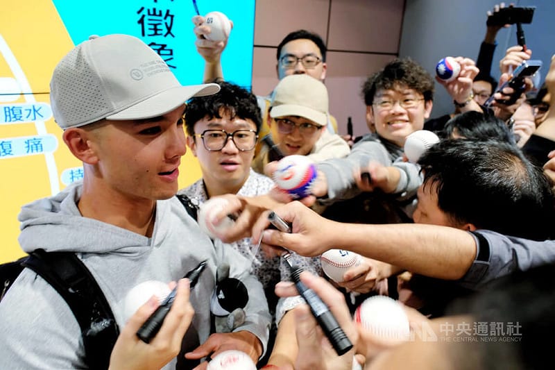 效力美國職棒大聯盟克里夫蘭守護者隊的台美混血好手費柴德（Stuart Fairchild）（左）26日晚間搭機抵台，受到大批球迷熱情迎接，費柴德也親切為球迷簽名。 &nbsp;&nbsp;&nbsp;圖/中央社