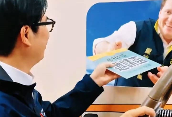 美國在台協會高雄分處長張子霖(右)向陳其邁(左)遞交2026日光海島生活節邀請函。&nbsp;&nbsp;&nbsp;圖：高雄市行國處/提供