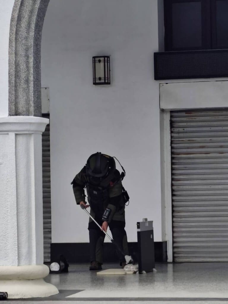 花蓮地方法院大門21日遭不明人士放置可疑包裹，防爆小組到場後拉起封鎖線，人員全副武裝謹慎處理，現場以X光機掃描檢視包裹，並將紙袋放入防爆箱內。（花蓮地檢署提供）中央社記者張祈傳真　115年3月21日&nbsp;&nbsp;&nbsp;