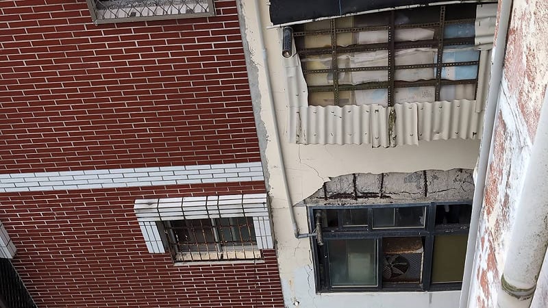 房屋後方常有大面積的水泥塊無預警掉落，一旦有重物從高處墜落撞擊力道非常驚人，若不幸打到路過的居民或行人，後果不堪設想。 圖：吳欣岱辦公室 提供 