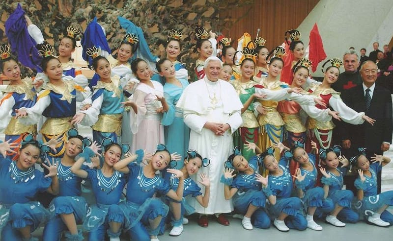 從30人到萬人觀眾,長達半世紀,秘神父與蘭陽舞蹈團為台灣結交了許多好友。圖為梵蒂岡演出獲教宗本篤十六世(圖中)接見。右二立者為秘神父。 圖:蘭陽青年會/提供 從30人到萬人觀眾,長達半世紀,秘神父與蘭陽舞蹈團為台灣結交了許多好友。圖為梵蒂岡演出獲教宗本篤十六世(圖中)接見。右二立者為秘神父。 圖:蘭陽青年會/提供