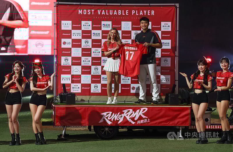 中華職棒5日在天母棒球場進行台鋼雄鷹隊與味全龍隊賽事，龍隊先發投手郭郁政（後右）以68球投完6局無失分，賽後獲選單場MVP，並獲贈台美混血好手費柴德太太韓納（Hanna Fairchild）（後左）的簽名衣。中央社記者張新偉攝　115年4月5日&nbsp;&nbsp;&nbsp;