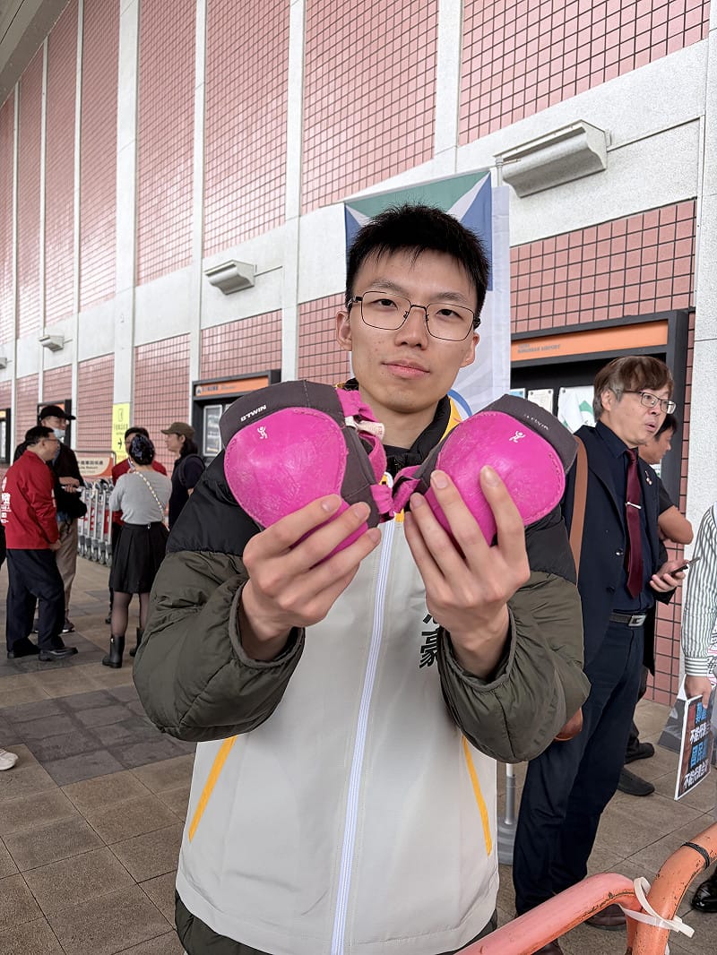 時代力量台北市士林、北投選區市議員參選人謝閔弘為國民黨主席鄭麗文送上「一對護膝」。 圖:李宣萱/攝 時代力量台北市士林、北投選區市議員參選人謝閔弘為國民黨主席鄭麗文送上「一對護膝」。 圖:李宣萱/攝
