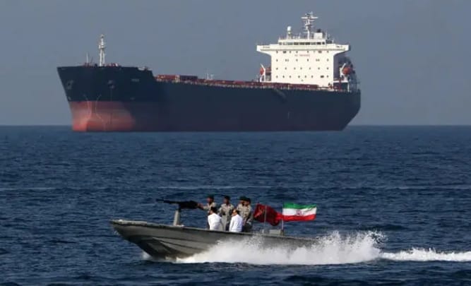一艘伊朗革命衛隊的快艇在荷姆茲海峽經過一艘油輪。&nbsp;&nbsp;&nbsp;圖 : 翻攝自鳳凰網
