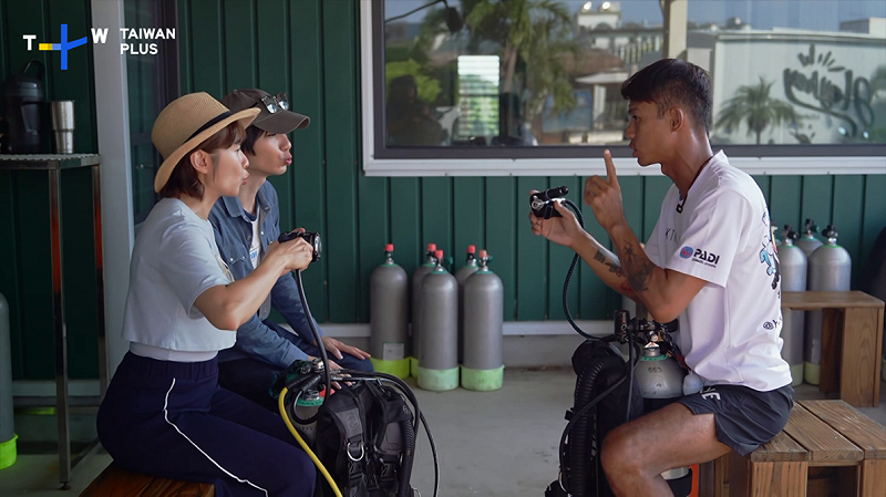 兩位主持人在潛水前學習如何使用氧氣瓶。.&nbsp;&nbsp;&nbsp;圖：TaiwanPlus提供