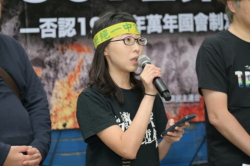  台灣人權促進會秘書長余宜家向前來參與遊行的群眾呼籲，一起否認由「萬年國代」所制定的憲法增修條文的效力，「而在未來的某一天，我們也要以台灣為名，制定一部真正屬於台灣人民的完整新憲法。」 圖：台灣經濟民主連合 提供 