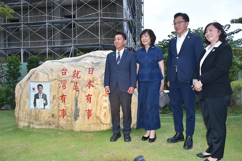 安倍昭惠(左二)、許智傑(左一)、林智鴻(右二)在「台灣有事就是日本有事」字樣的大石旁合影。&nbsp;&nbsp;&nbsp;圖：孫家銘/攝