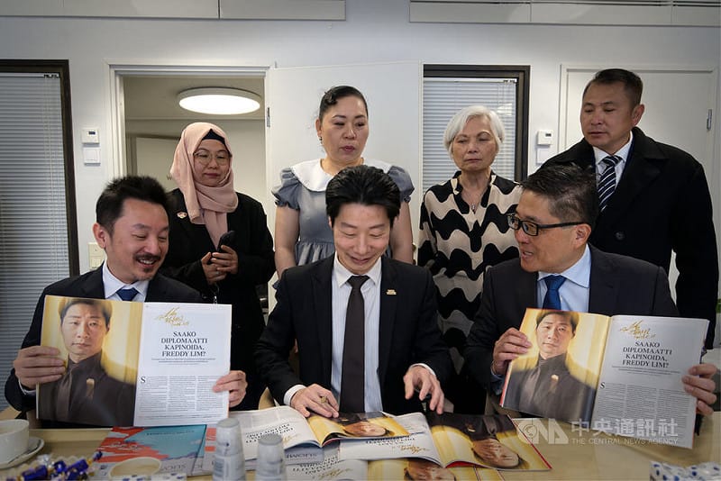 駐芬蘭代表林昶佐（前中）贈台商刊登其專訪的百年政經雜誌「芬蘭畫報」，並以老派鋼筆逐一簽名。&nbsp;&nbsp;&nbsp;圖：中央社