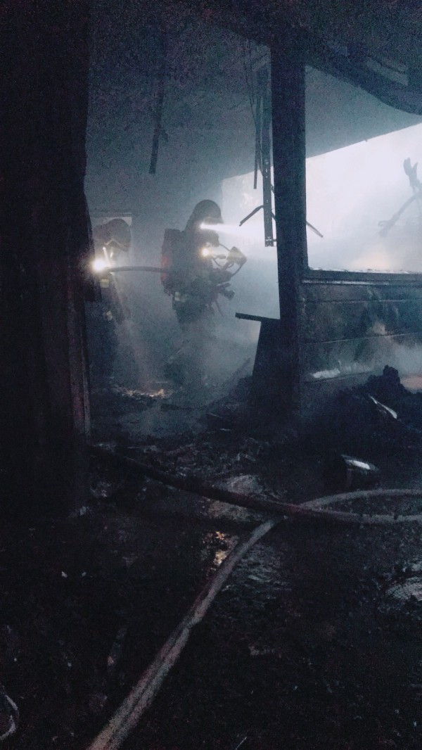 新埔鎮義民路一間民宅旁鐵皮倉庫凌晨發生火警，現場發現一具男焦屍。   （新竹縣消防局提供）