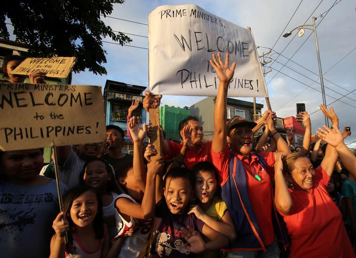 在一家速食餐廳外，數以百計群眾在杜魯道上車時高聲尖叫，搖著手中看似倉促寫下的「歡迎來到菲律賓！」標語。   圖：達志影像/路透社