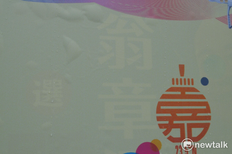 因台灣燈會廣告底色為淡黃色，隱隱透出「翁章」及「選」字。   蔡坤龍/攝