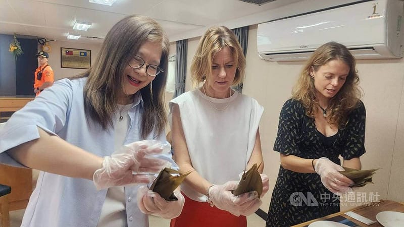 端午將至，海委會主委管碧玲（左）邀英國在台辦事處代表包瓊郁（中）登上雲林艦，管碧玲也示範折粽葉、填料及綁繩技巧，並按步驟教導包瓊郁包出人生第一顆台灣粽。中央社記者洪學廣攝　115年6月18日&nbsp;&nbsp;&nbsp;