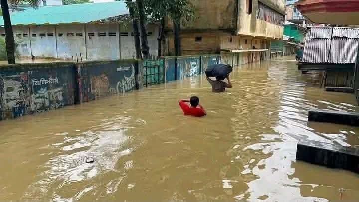 洪水沖進孟加拉多座城鎮，災民在被淹沒的街道中搬運物資。 圖：翻攝自 Ｘ @ForhadMamud 