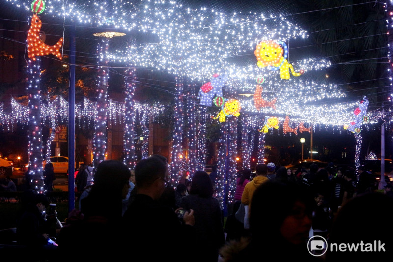 .新北歡樂耶誕城周遭以白雪點綴的燈飾，呈現浪漫氣氛，不少情侶在現場合影或現場直播。   圖：王峻昌/攝