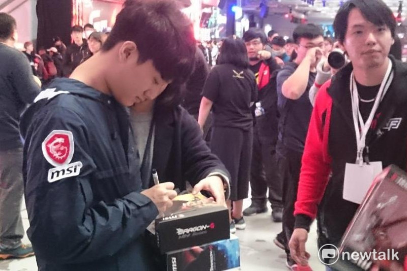 幫粉絲在義賣商品上簽名的蛇蛇（左）。   圖：王昱澄/攝