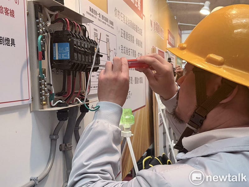 勞動部長洪申翰在活動中體驗水電工的接線技術。 圖:李宣萱/攝 勞動部長洪申翰在活動中體驗水電工的接線技術。 圖:李宣萱/攝