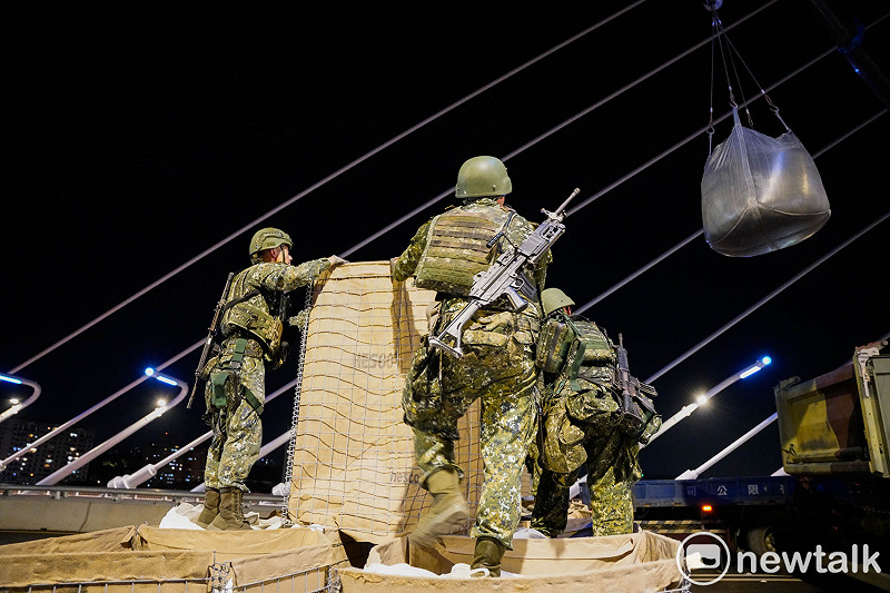 陸軍工兵群士兵將大貨車上的大型沙包放置在阻絕牆內。&nbsp;&nbsp;&nbsp;圖：張良一/攝