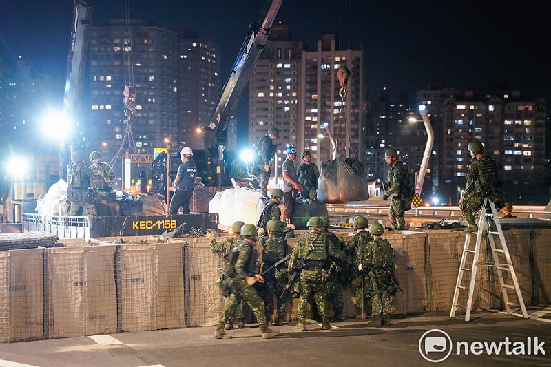 陸軍工兵群士兵將大貨車上的大型沙包放置在阻絕牆內。&nbsp;&nbsp;&nbsp;圖：張良一/攝