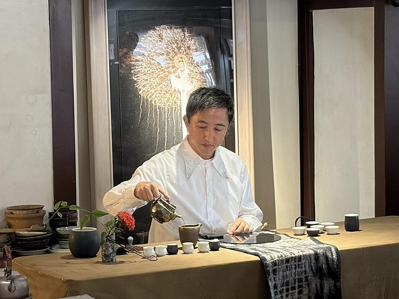 李坤霖老師則以「彈茶」為理念，靈感汲取自「鋼琴鍵」，將茶席化身為優雅的音樂廳，象徵文化交流正如流動的旋律。他特別採用台灣特有的「雙杯品香法」，以黑白二色茶杯象徵琴鍵與音符；翻杯品香時，猶如指尖在琴鍵上輕盈跳躍。席間更巧妙融入茶譜與爬藤花藝，宛如音符躍動，完美營造出「以茶為琴，彈茶談茶」的動人意境。&nbsp;&nbsp;&nbsp;圖：黃博郎／攝