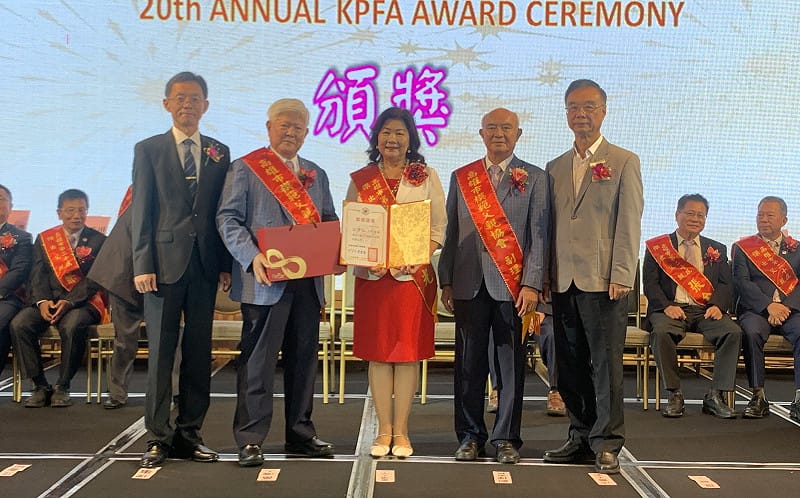 邱綉惠(中)代表公差不克出席的先生古源光上台領取當選證書與禮品。&nbsp;&nbsp;&nbsp;圖：孫家銘攝
