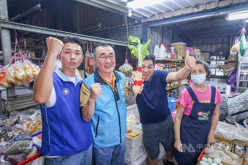 國民黨新北市長參選人李四川（左2）6日勤走三鶯地區，冒雨掃街拜票，有攤商送上象徵好彩頭的蘿蔔表達支持。&nbsp;&nbsp;&nbsp;圖:中央社提供