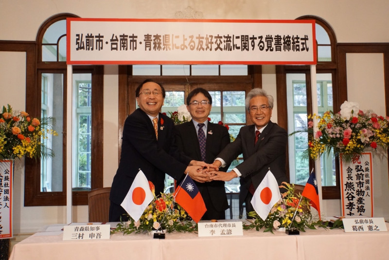 臺南市李孟諺代理市長在日本青森縣弘前市著名的藤田紀念庭園，跟青森縣三村申吾知事以及弘前市葛西憲之市長共同簽署三方友好交流備忘錄。   圖 : 台南市政府/ 提供