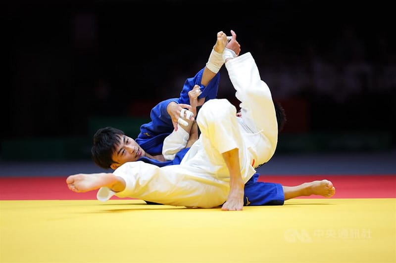 名古屋亞運30日柔道男子60公斤級銅牌戰，台灣柔道一哥楊勇緯（藍衣）多次使用招牌地板動作，與中國對手僵持近20分鐘，仍不敵對手落敗。中央社記者翁睿坤愛知攝　115年9月30日&nbsp;&nbsp;&nbsp;