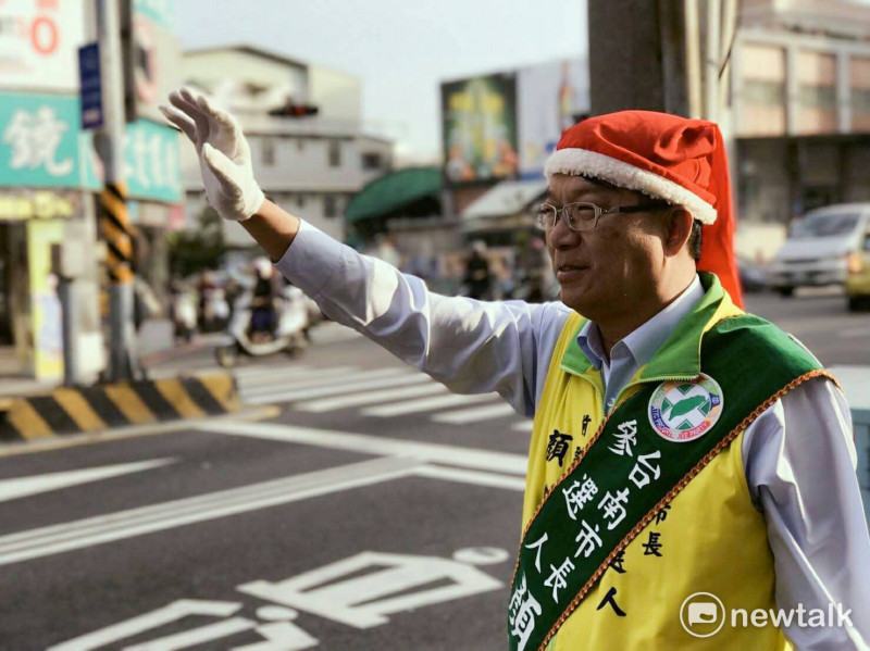 顏純左站在南門路口拜票，並戴上聖誕帽，提早向市民祝福聖誕快樂。   圖 : 黃博郎/攝