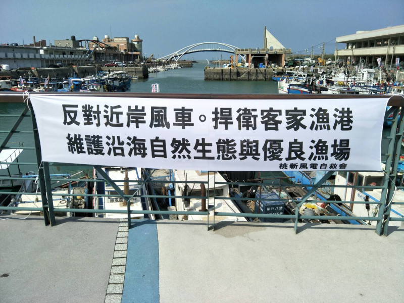 桃新沿海風電自救會在台灣一個客家漁港豎起抗議布條，反對距離500公尺的近岸風機。   圖:桃新沿海風電自救會／提供