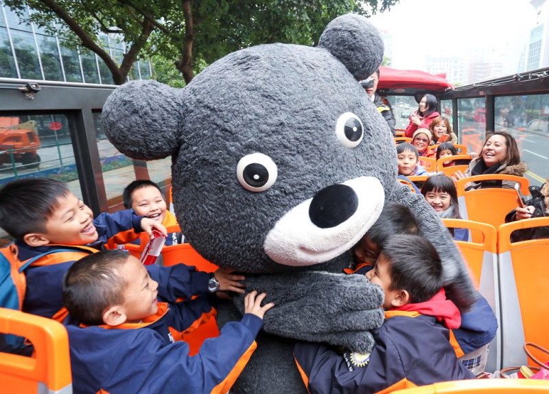 熊讚一上車就廣受學生熱烈歡迎，一次熊抱二位小朋友。   圖 : 台北市觀傳局/提供