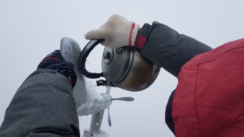 為了使器材能正常運作，觀測站人員澆水融化冰塊。   圖：中央氣象局提供
