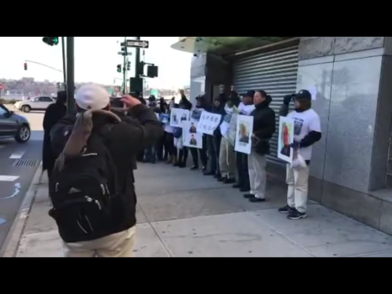 一群海外華人手持抗議標語，前往中國駐紐約領事館前聲援吳淦。由於適逢聖誕假期，領事館拉下鐵門，大門深鎖。   圖：翻攝自Youtube