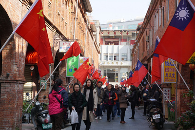 日是中華民國107年元旦，金門模範街上青天白日滿地紅國旗和中國大陸五星旗同步飄揚，有民眾和遊客爭相拍照打卡，但也有人認為怪怪的。   圖 : 中央社