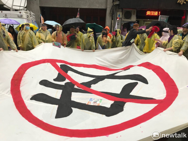 移工團體準備巨幅「反奴」旗幟。   圖 : 周煊惠 / 攝