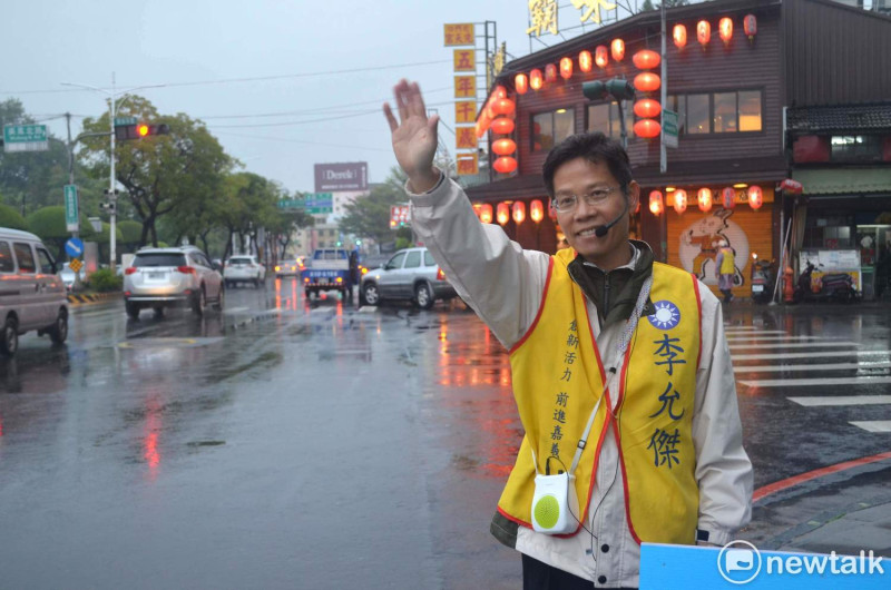 李允傑三次在吳鳳北路、林森路口拜票，都遇到下雨，他說「風雨生信心」。   圖：蔡坤龍/攝