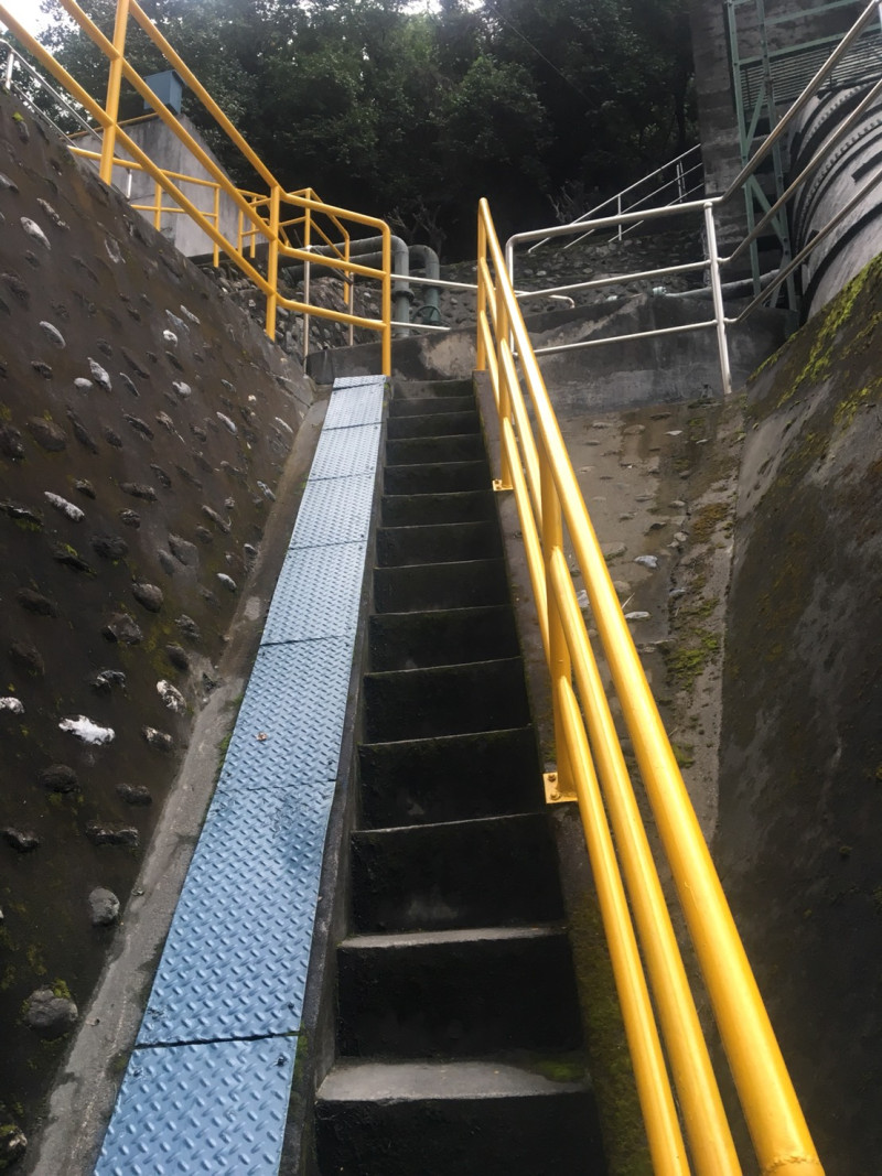 台電建置微水力機組的人員，得扛著管線走上狹窄鐵樓梯。   圖：台電提供