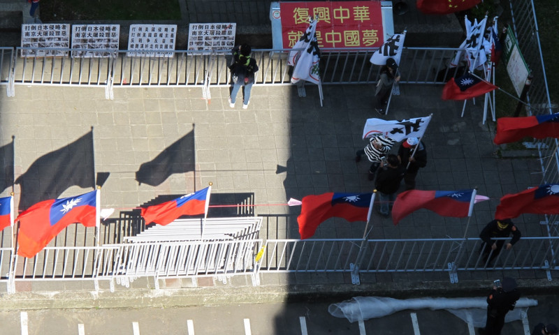 警方17日搬來11面旗子插在愛國同心會前。   圖：林朝億/攝