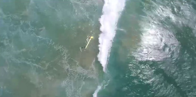 一架澳洲無人駕駛救生機18日拋下救生設備，營救兩名受困3公尺巨浪中的少年。   圖：翻攝youtube