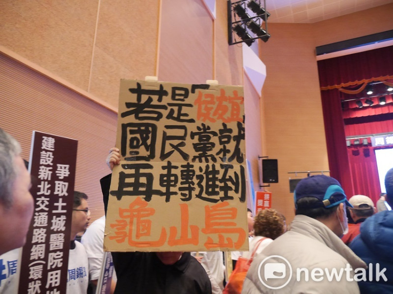 活動現場有人舉牌，暗批新北市副市長侯友宜。   圖：趙婉淳／攝