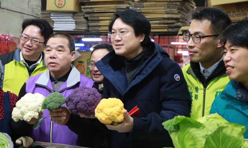 在向攤商們拜年同時，林右昌仍不忘關心年節期間的果菜行情。   圖：基隆市政府/提供