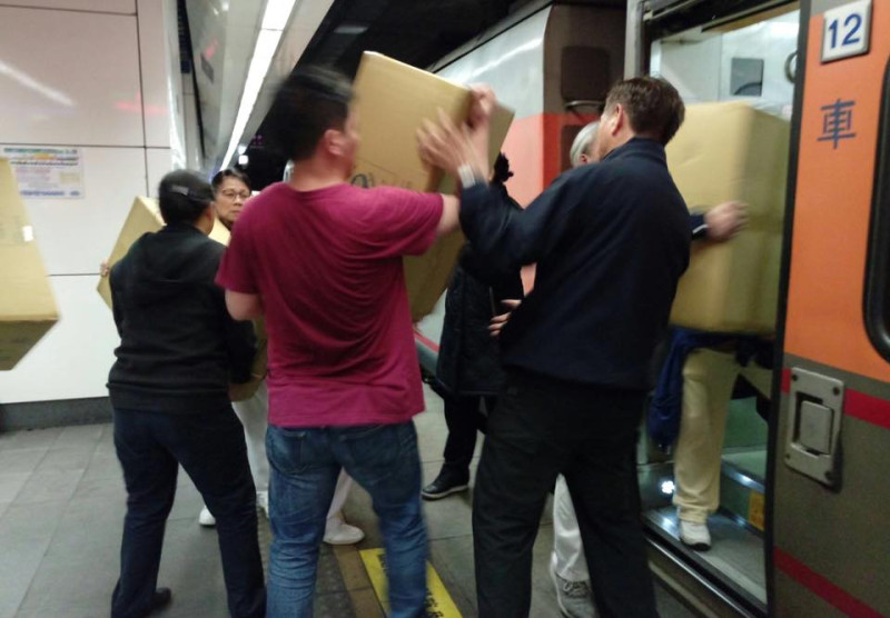 慈濟準備多箱物資準備運往花蓮災區，許多旅客自動自發下車幫忙。   圖：翻攝自「慈濟＠臺北」臉書