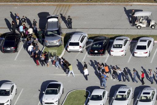 美國佛羅里達州發生槍擊事件後，學生在警方的安排下，離開槍擊現場，這場校園槍擊事件造成17人死亡。   圖 : 達志影像/ 美聯社（資料照片）
