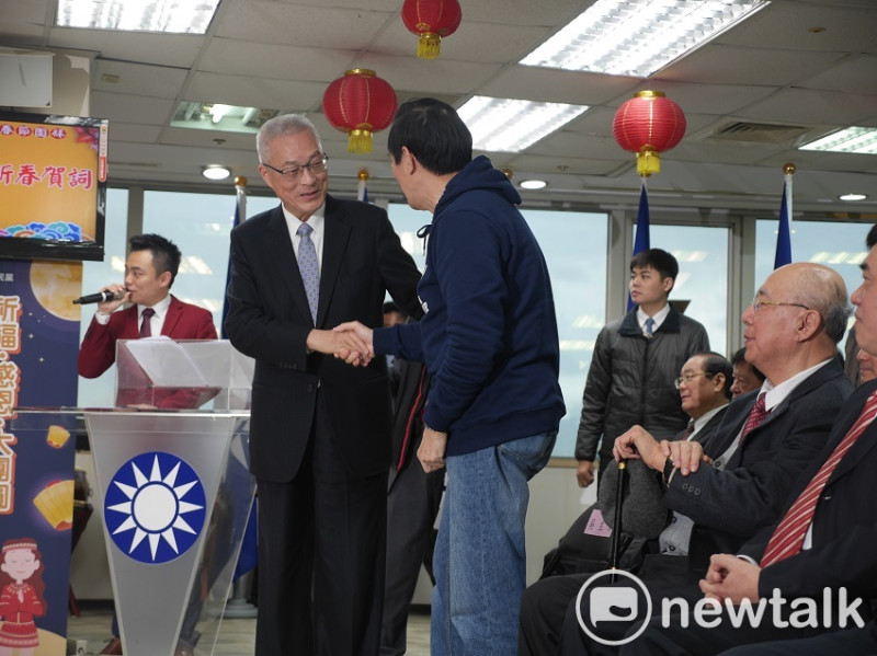 國民黨主席吳敦義致詞完畢下台時，前總統馬英九起身握手致意。   圖：趙婉淳／攝