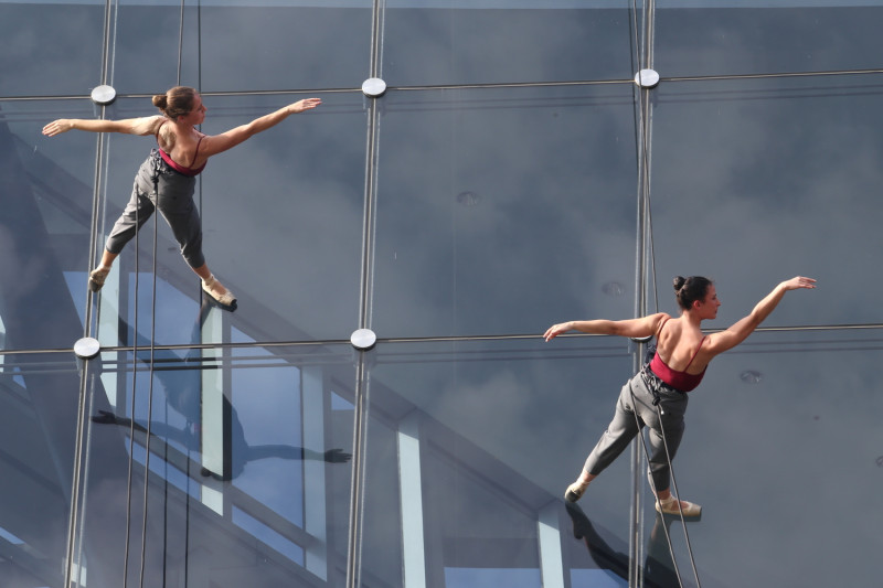 舞者倒吊在大面玻璃上跳芭雷。   圖：嘉義縣政府/提供